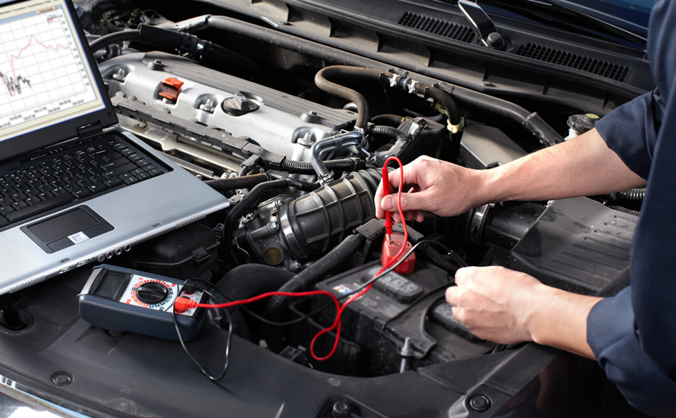 Mechanic checking battery levels on a vehicle.